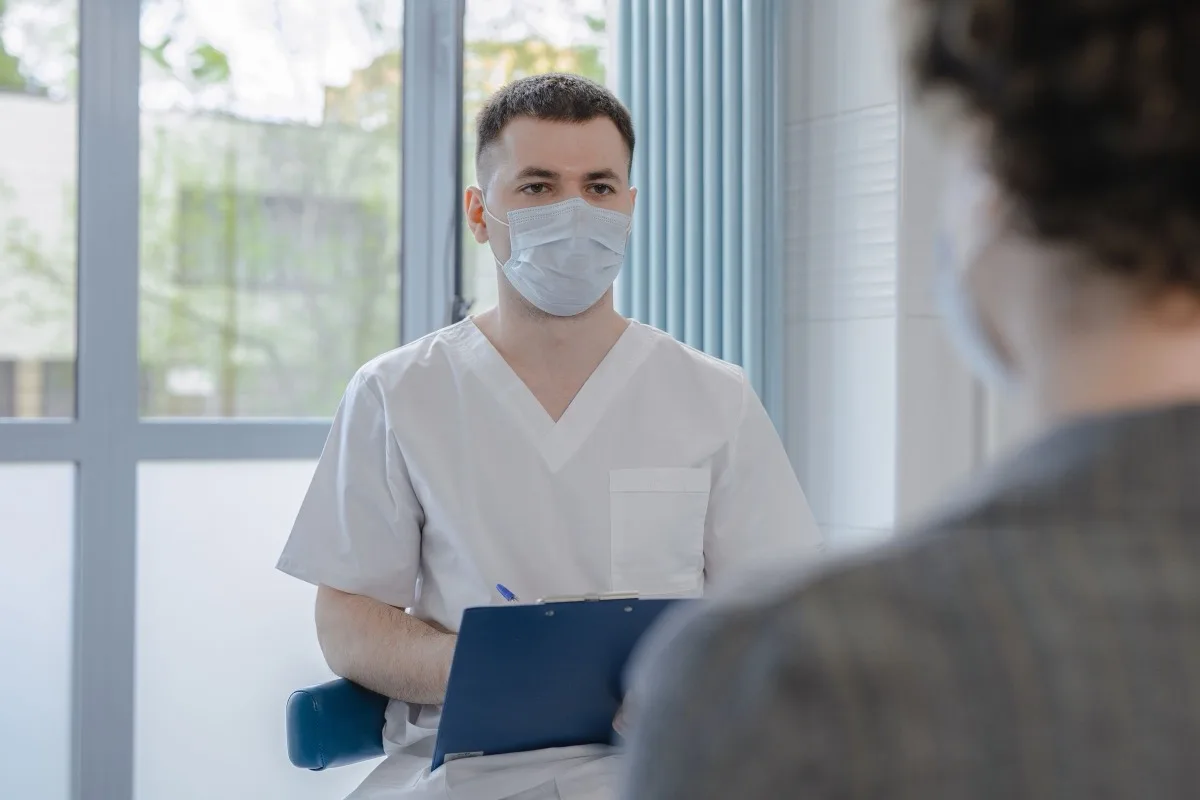 Médico conversando con un paciente durante una consulta de seguimiento postoperatorio